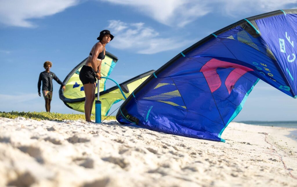 Kiterin pumpt ihren Kite am Strand auf - Redshark