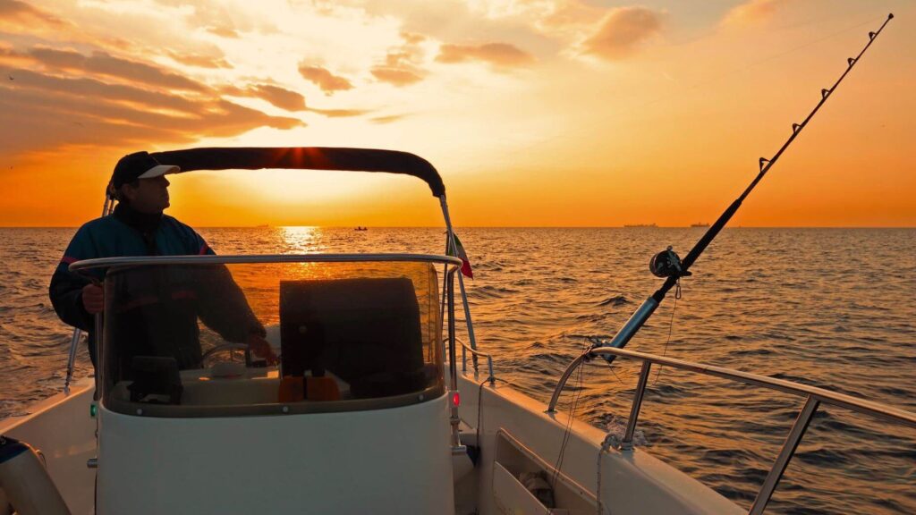Fischer auf einem Boot im Sonnenaufgang - Redshark